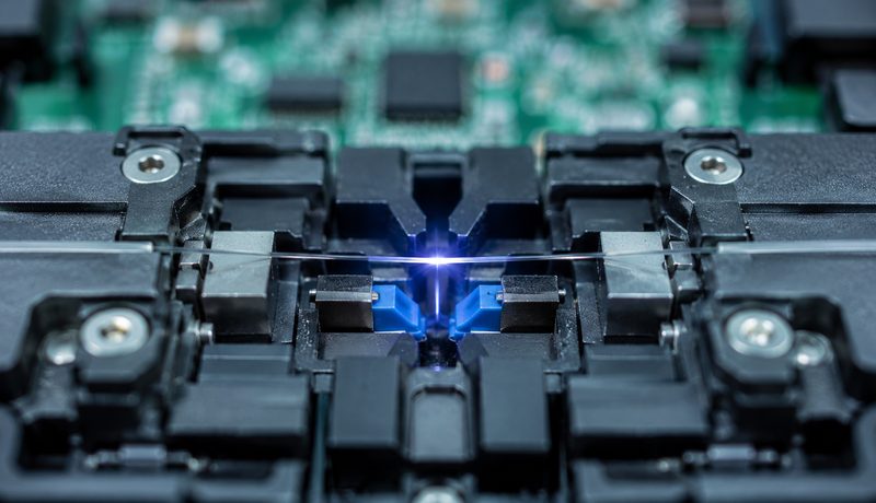 Fusion splicer joining two optical fibres with a glowing arc